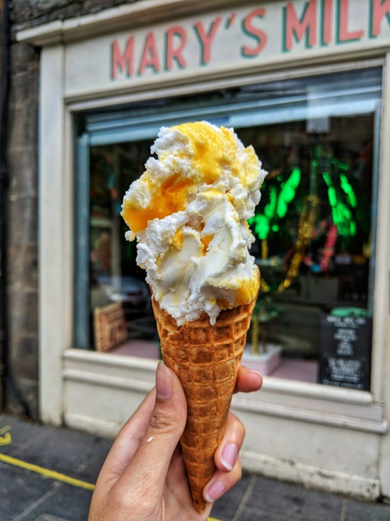 hand holding an Orange Ice Cream filled cone