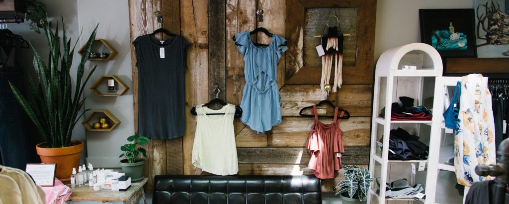 clothing displayed for sale on a wooden wall