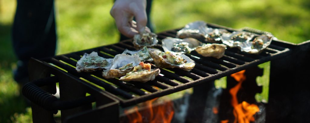 Wescott Bay oysters being grilled over a campfire