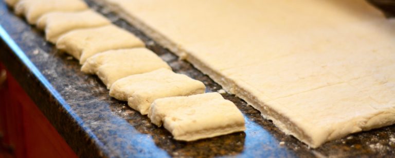 pastry dough being cut into squares