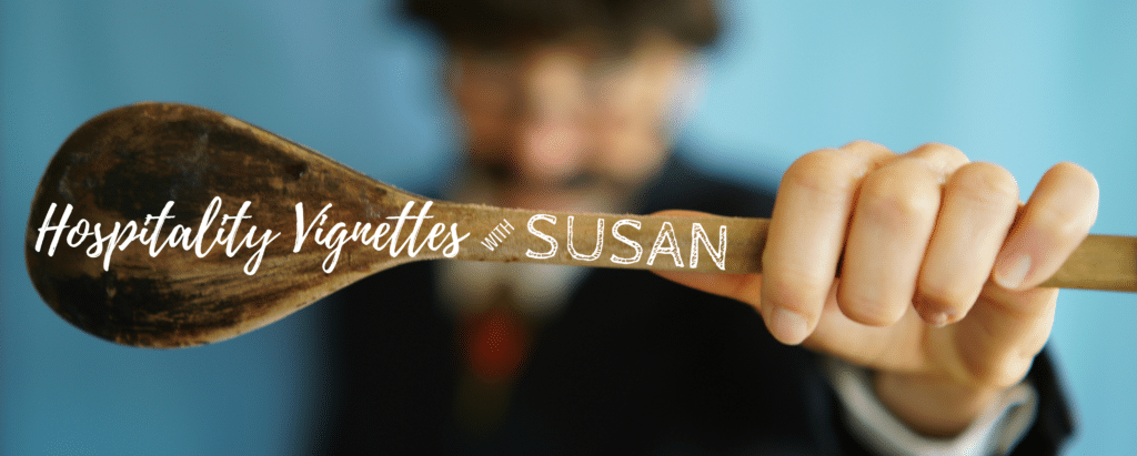 person holding a wooden spoon with the phrase hospitality vignettes with Susan superimposed overtop