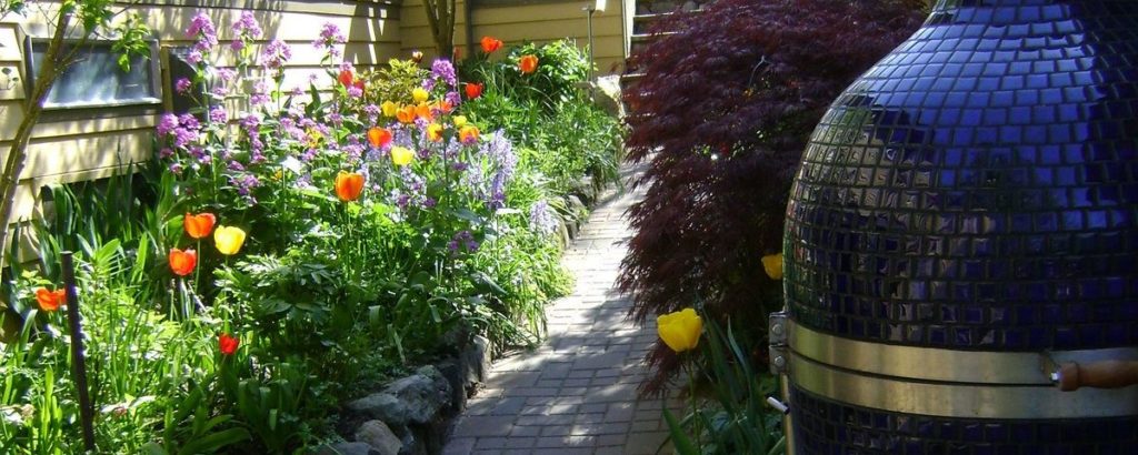 brick path through a garden in bloom