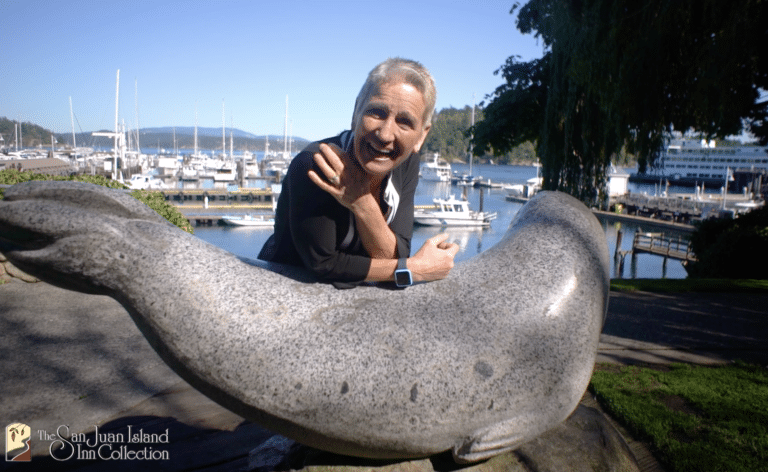 woman leaning on a sculpture of a seal