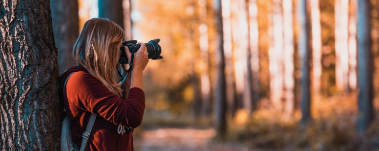 girl taking photo in forest