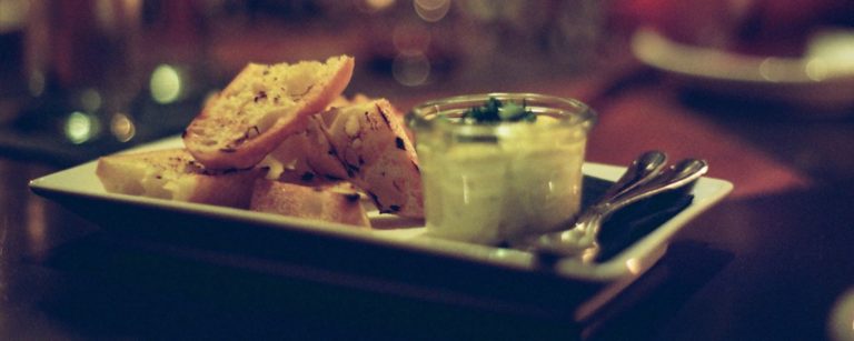 toasts and a small jar of spread on a plate