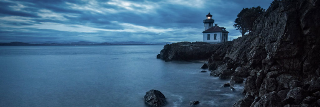 lighthouse at the edge of a rocky shoreline