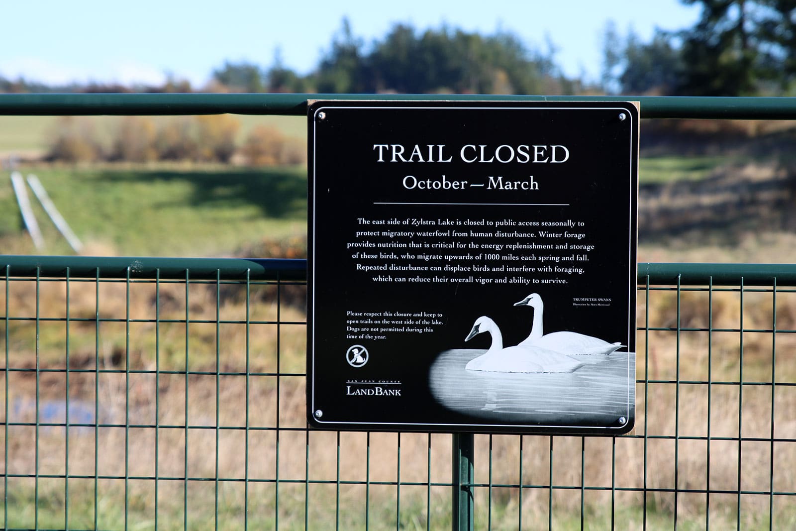 Sign on a fence announcing the trail is closed from October to March