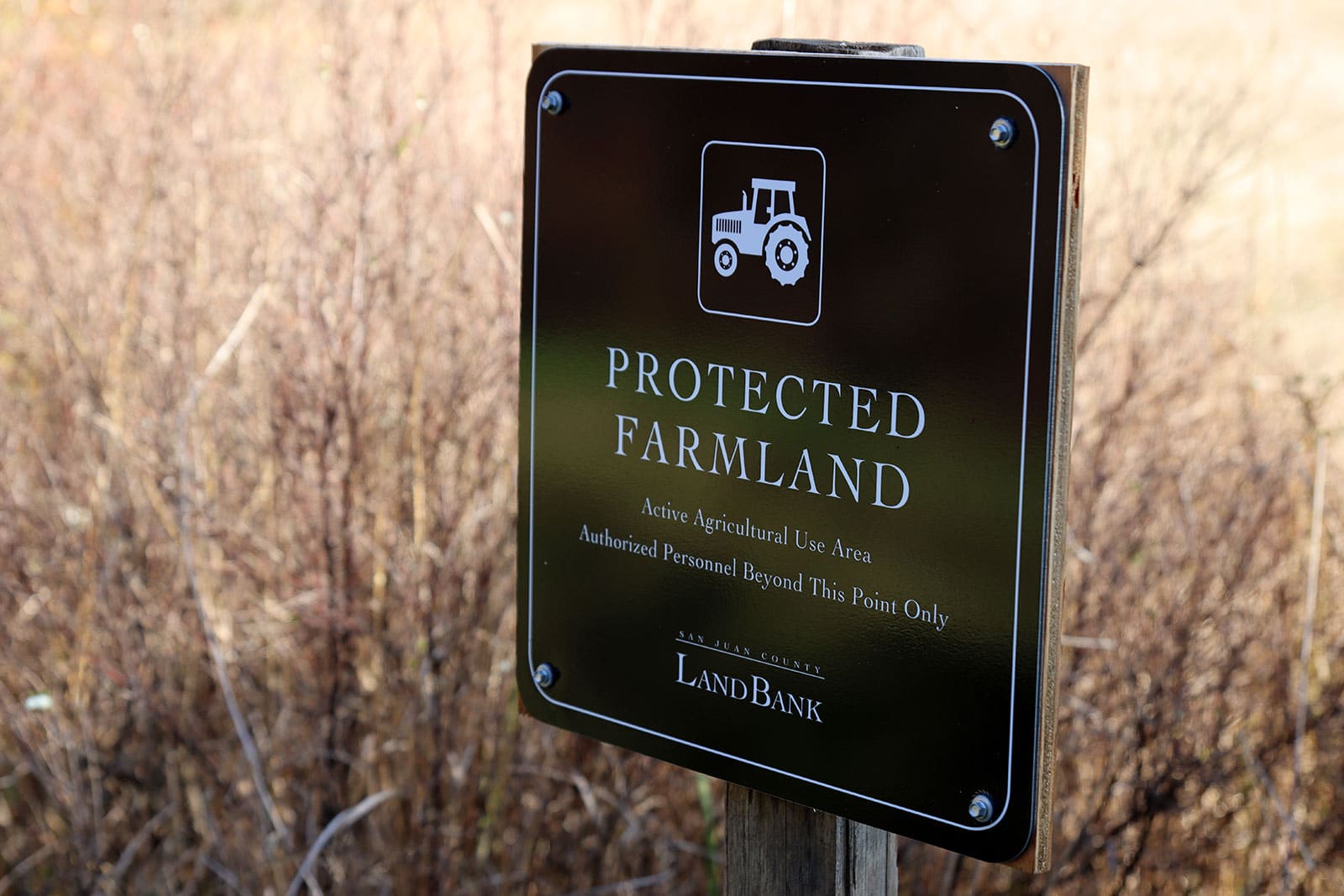 Protected Farmland sign in an unmowed field