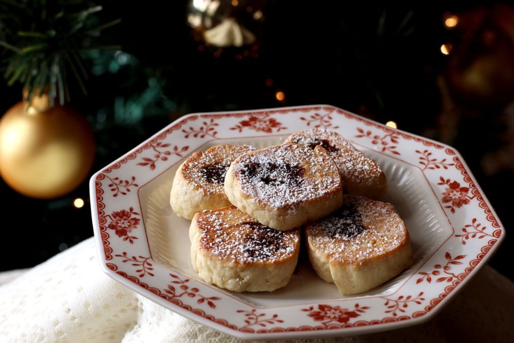 Five Fig cookies on a white and red china plate