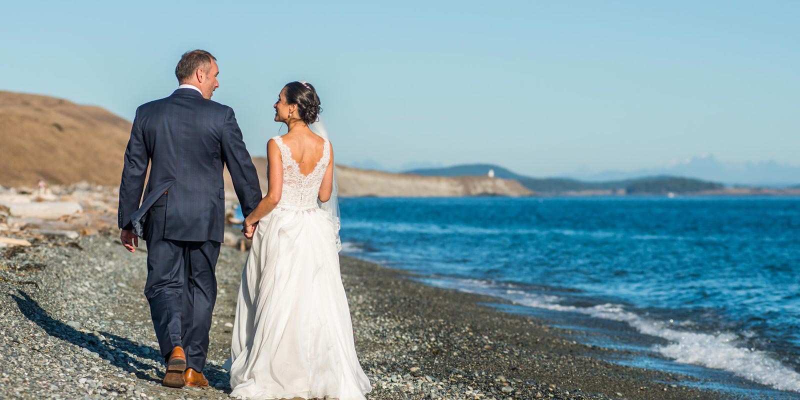 A couple enjoying a romantic moment on the beach during their wedding - something that's possible when you choose our San Juan Island wedding venues