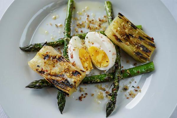 plate of hard boiled egg, roasted leeks and asparagus