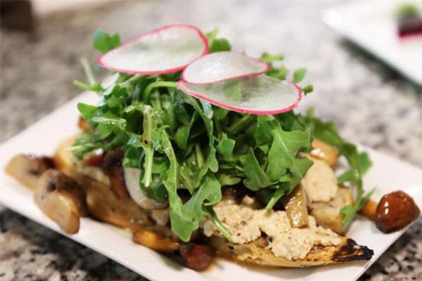 toast topped with mushrooms, greens and sliced radishes