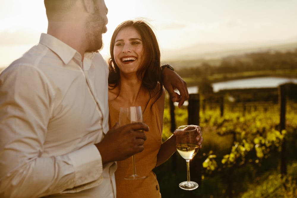 Couple holding wine glasses and smiling at one another