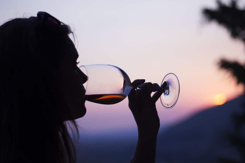 Profile of person drinking a glass of wine