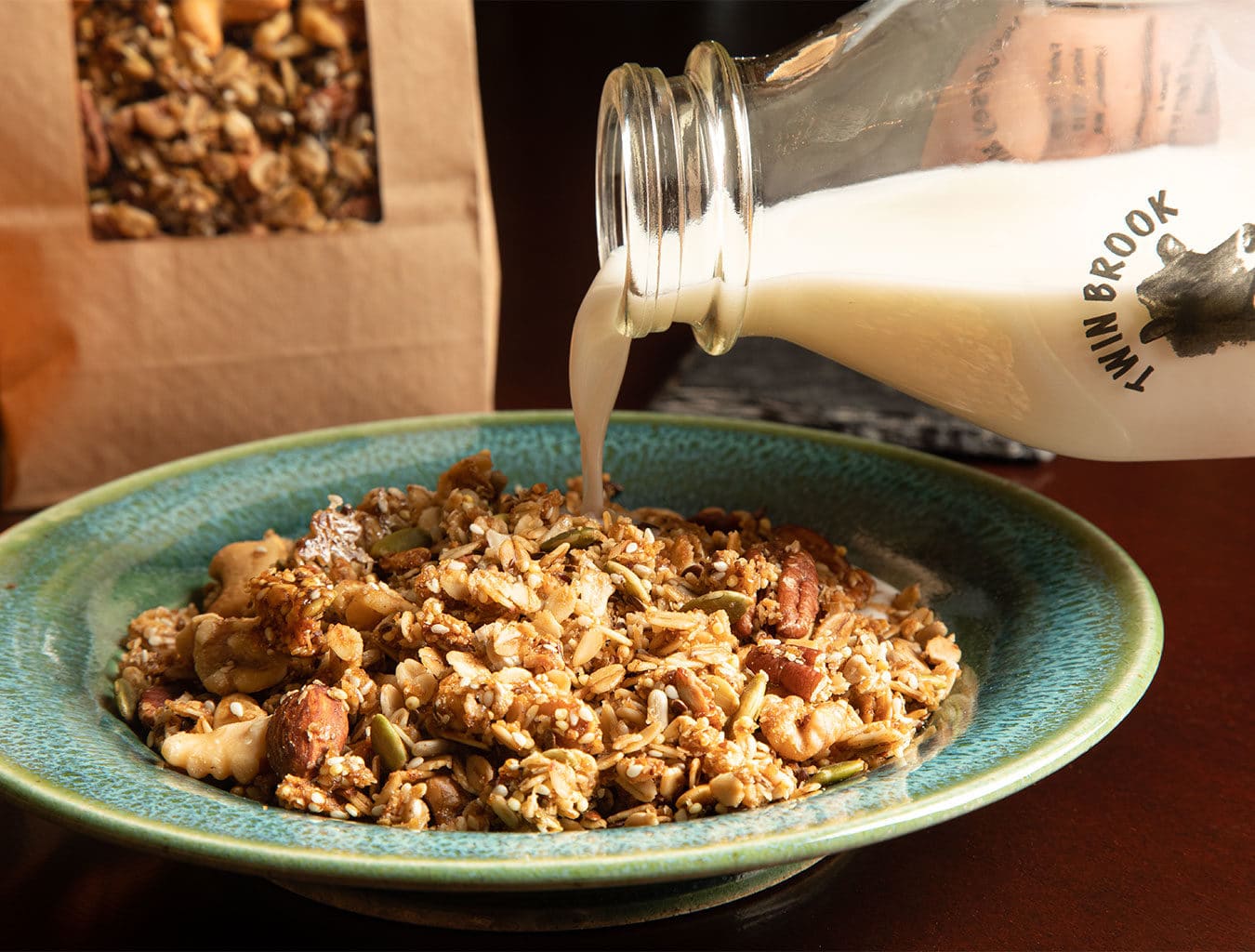 milk being poured from a bottle into a bowl of granola