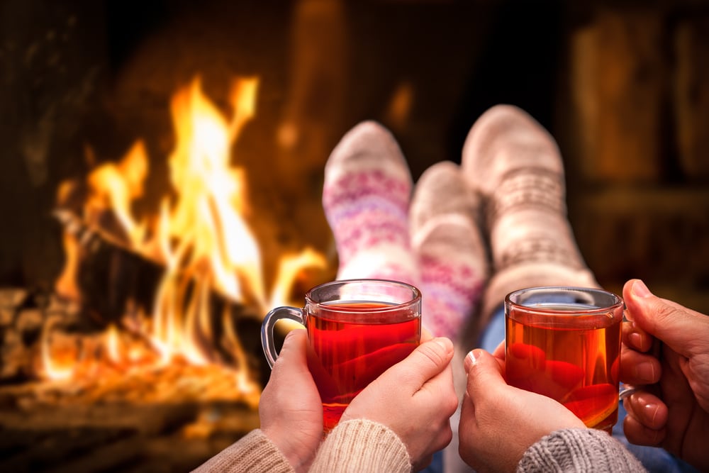 A couple relaxes with a warm drink in front of the fire at the Tucker House Inn, the best Friday Harbor lodging.